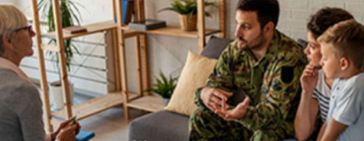 people-on-couch | The United Methodist Church of Red Bank - Red Bank, NJ #Soldier in camouflage talks with a family (man and two kids) in a casual lounge setting.